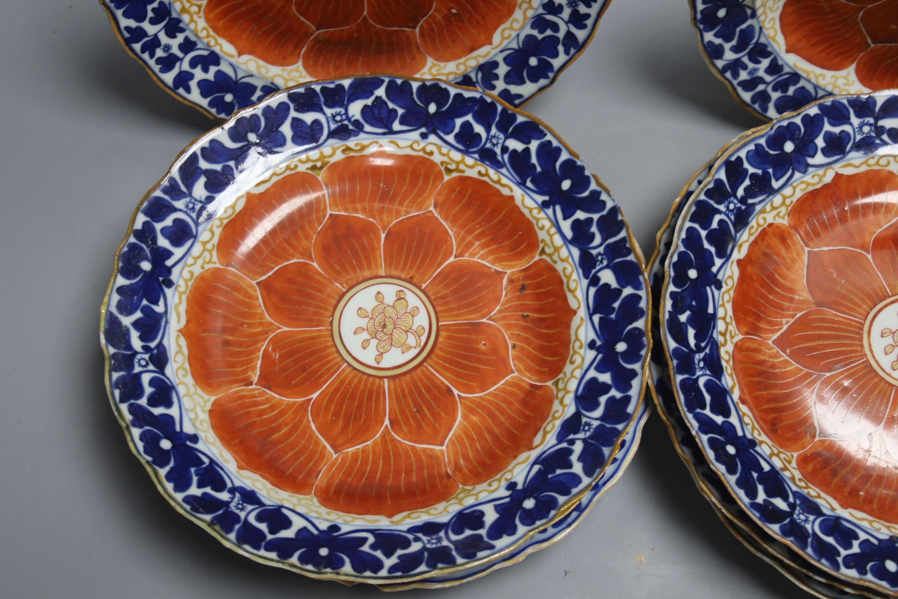 A set of eight Chinese plates with orange 'lotus' centres and blue floral borders, Qing dynasty, Dia 20cm